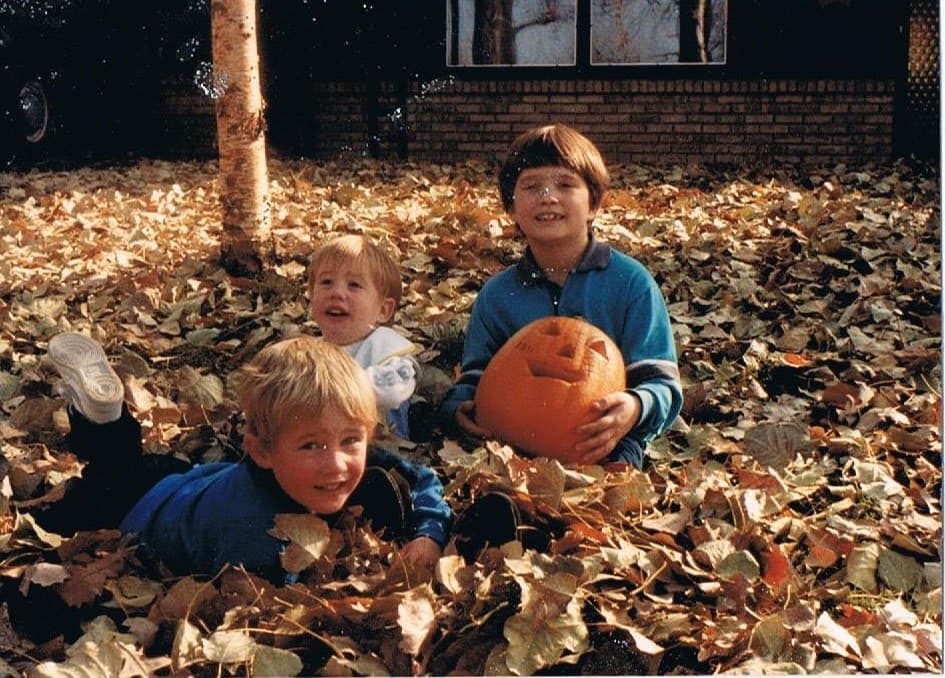 Three brothers Andrew, Joel, and David in autumn leaves